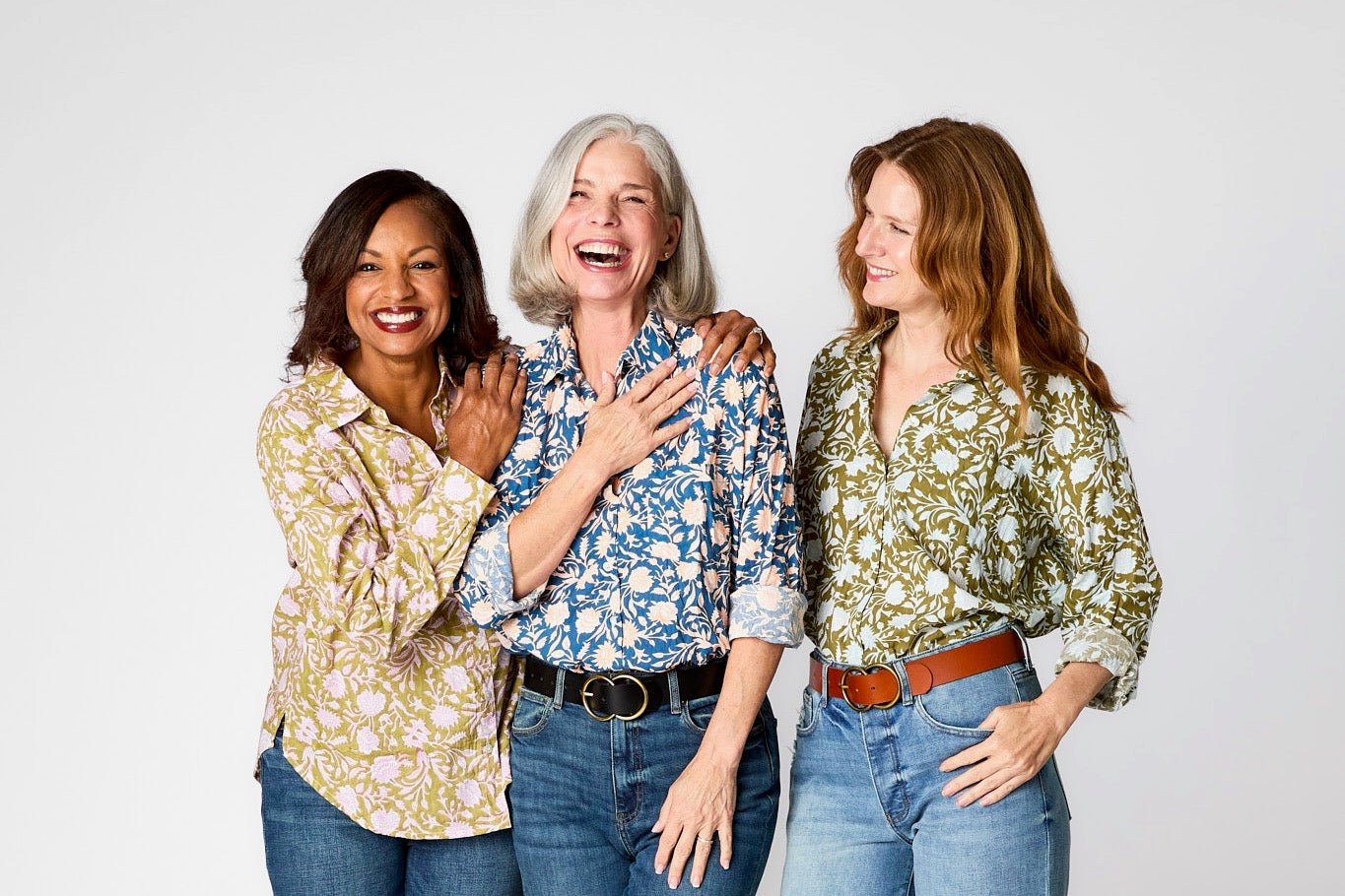 Three women wearing colorful natural-fabric shirts