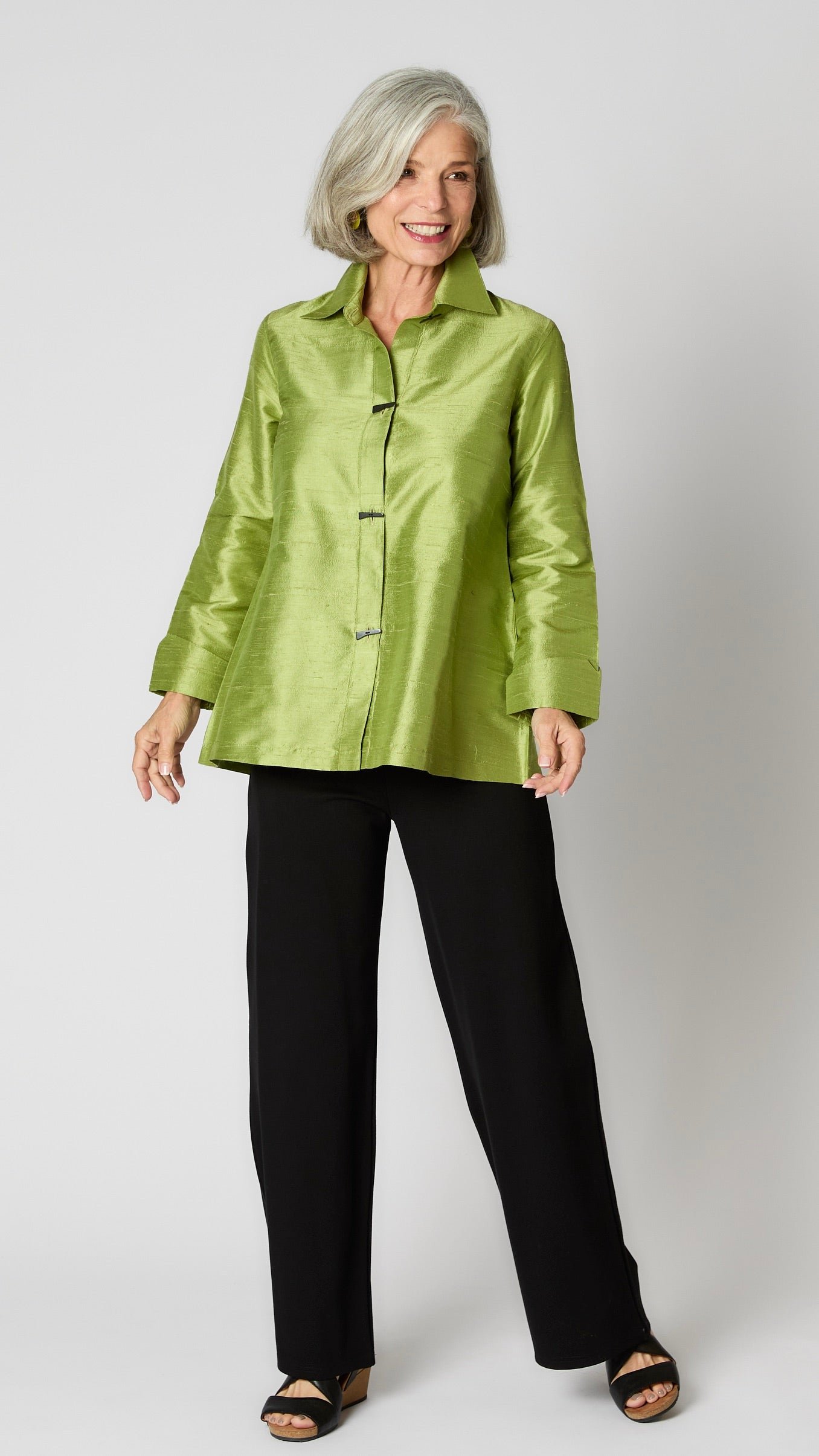 Model wearing citron raw silk button-up blouse with black horn buttons and 3/4 sleeves, black wideleg trousers, and black wedge sandals.