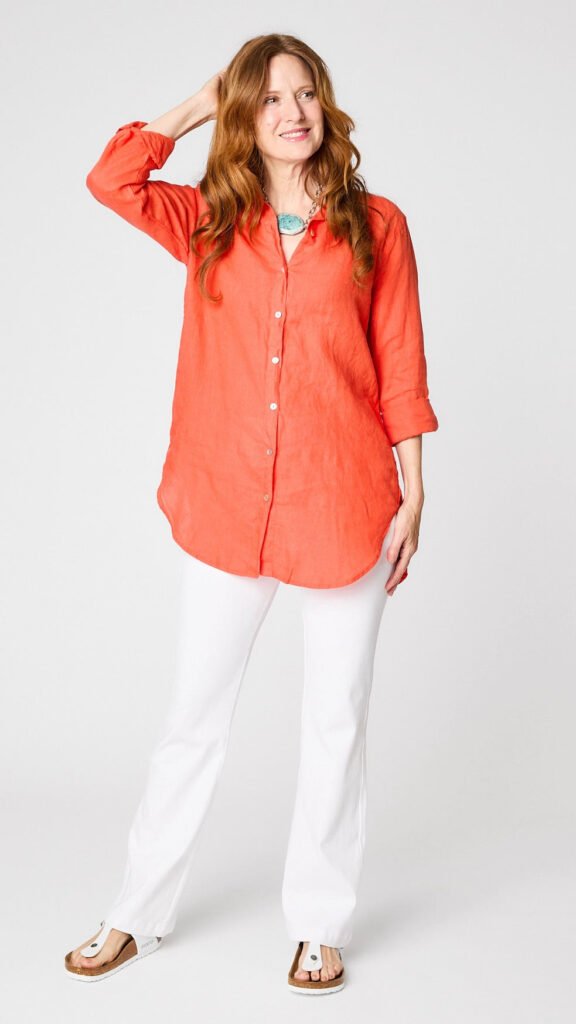 Model wearing tabasco linen boyfriend button-up shirt with white bootcut jeans and white sandals.