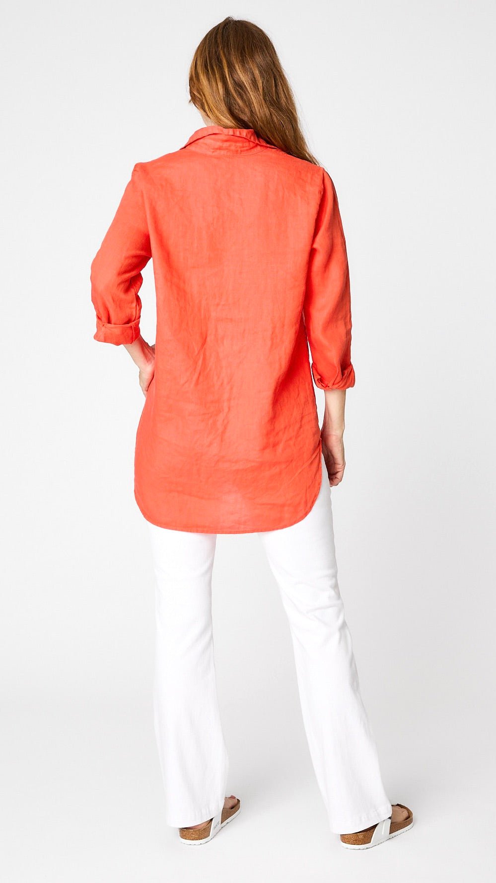 Model wearing tabasco linen boyfriend button-up shirt with white bootcut jeans and white sandals.