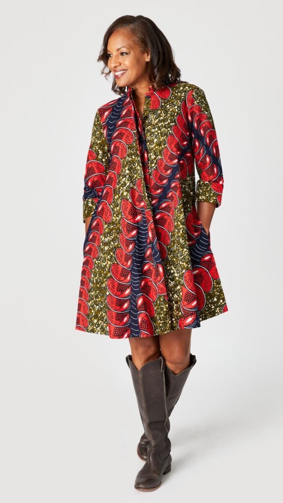 Model wearing "Red Herring" print Zuri dress with tall brown leather boots.